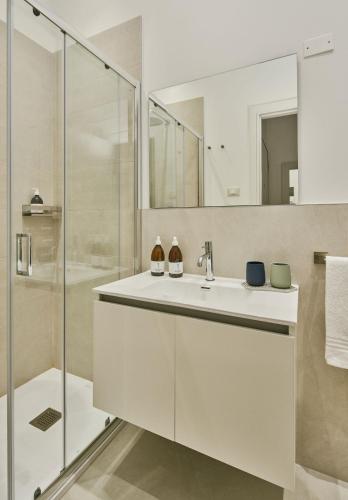 a white bathroom with a sink and a shower at URBANAUTS STUDIOS Ginnastica in Trieste