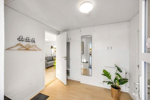 a living room with white walls and a mirror at FeWo Lille Vidstrup in Vidstrup