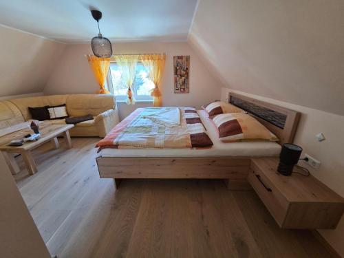 a bedroom with a large bed and a couch at Zu-Haus in Peterdorf
