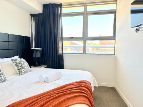 a bedroom with a bed with two towels on it at Chatswood Exeutive Condo - 2 Bedrooms 2 Bathrooms with King Bed in Sydney