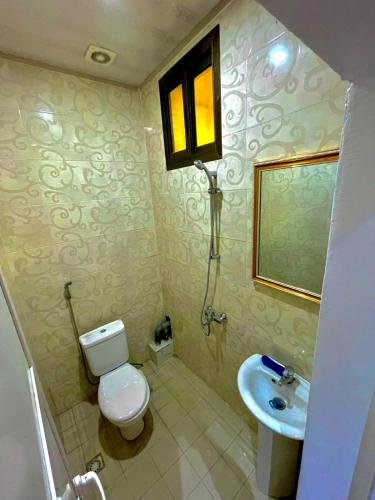 ein Badezimmer mit Toilette und Waschbecken in der Unterkunft Western Suites in Douala