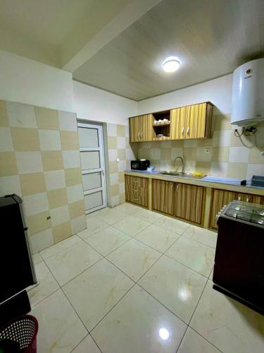 eine Küche mit Holzschränken und Fliesenboden in der Unterkunft Western Suites in Douala