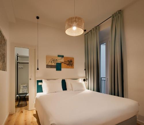 a bedroom with a large white bed and a lamp at URBANAUTS STUDIOS Ginnastica in Trieste