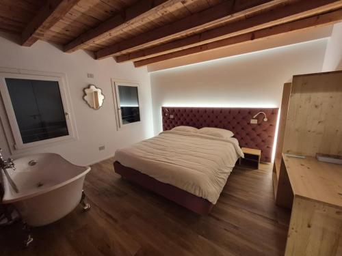 a bedroom with a bed and a tub and a sink at Dolce Bacio in Valdobbiadene