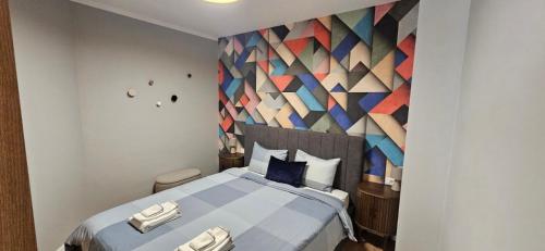 a bedroom with a large bed with a colorful wall at By The Pool Apartments #8 in Velingrad