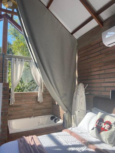 a bedroom with a bed and a bath tub at Pousada Jardins da Gastehaus in Triunfo