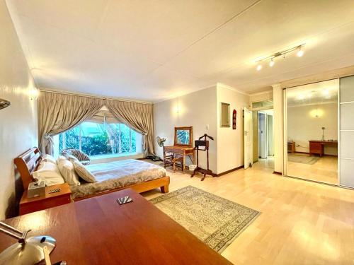 a bedroom with a bed and a large window at Suburban tranquility in Johannesburg