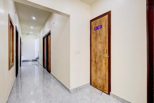 a hallway with a wooden door in a building at Hotel O DREAM INN in Alwar