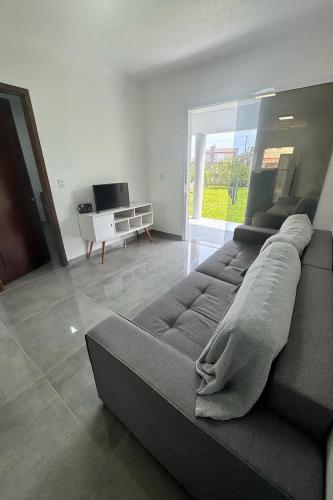 a large couch in a living room with a television at Casa nova em Torres in Torres