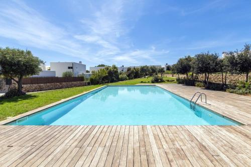 a large swimming pool with a wooden deck at Biniancolla Ginesta in Biniancolla