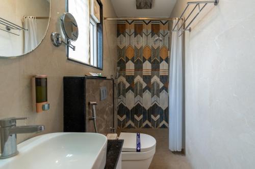 a bathroom with a toilet and a sink and a mirror at HOTEL BLUEMOON in Tirunelveli