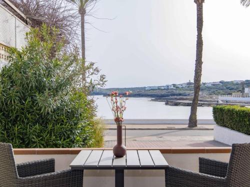 a vase on a table with a view of the water at Villa Gavines down in S'Algar