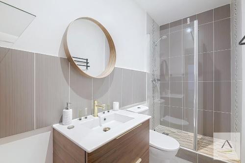une salle de bains avec lavabo, miroir et toilettes dans l'établissement L'Ecluse, à Dinard