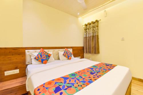 a bedroom with a large bed with colorful pillows at FabHotel Aishwarya in Kota