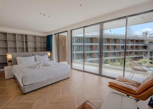 a bedroom with a bed and a large window at Beachfront 267 3BR Condo with Pool View in Phuket
