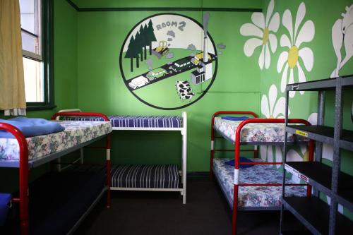 a room with three bunk beds and a mirror at Old Fire Station Backpackers in Fremantle