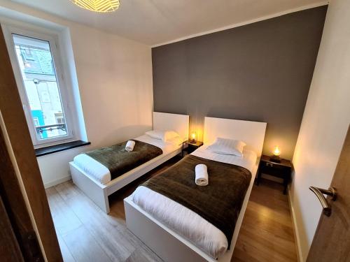 a bedroom with two beds and a window at Faubourg des voyageurs 6 - T3 climatisé 4 personnes - proche axe autoroute et gare in Saran