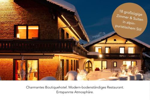 a picture of a house with snow in front of it at freistil Boutiquehotel in Sonthofen