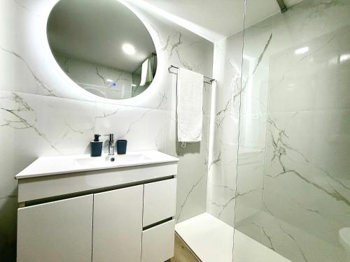 a white bathroom with a sink and a mirror at Casa do Castello Chaves in Chaves