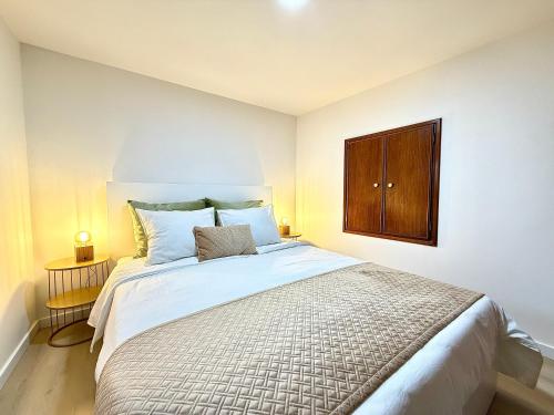 a bedroom with a large bed with a wooden cabinet at Casa do Castello Chaves in Chaves