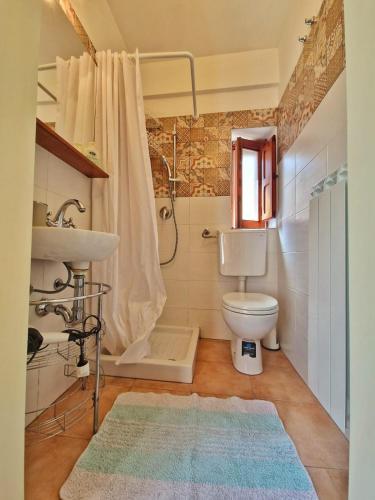 a bathroom with a toilet and a sink and a shower at A Casa da Vita in Chiaramonte Gulfi