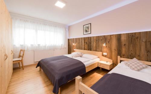 ein Schlafzimmer mit zwei Betten und einem Fenster in der Unterkunft Bachmannhof in Feldthurns