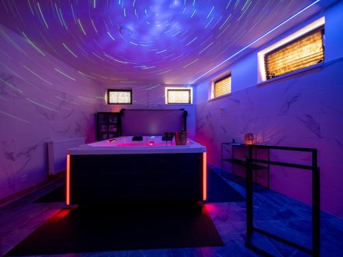a room with a tub in a room with purple lights at Hideaway in Ostrava