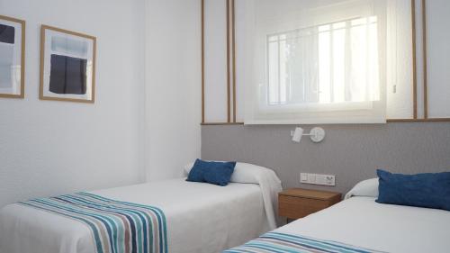 a room with two beds and a window at Apartamentos BCL Playa Albir in Albir
