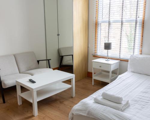 a room with a bed and a couch and a table at Studio apartment next to Highgate tube station in London