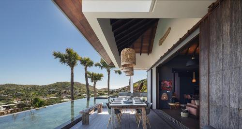 a house with a view of the ocean and palm trees at Smart Elegant Villa with Amazing Tropical Views in Toiny