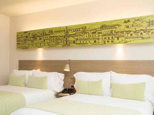 two beds in a hotel room with a painting on the wall at Hotel bh Usaquén in Bogotá