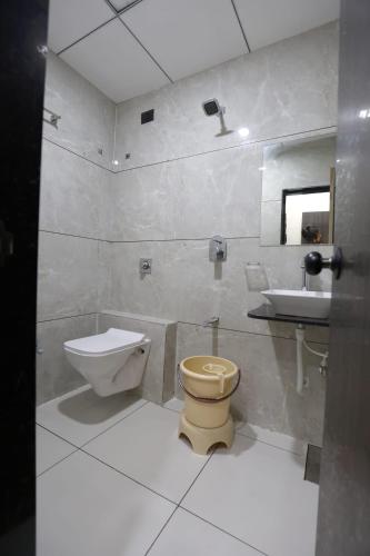 a bathroom with a toilet and a sink at Hotel Bansi Palace in Dwarka