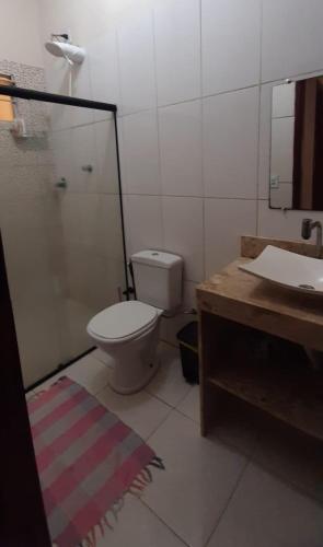 a bathroom with a toilet and a sink and a mirror at Casa da Meire in Prado