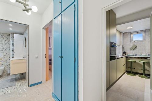 a bathroom with a blue door and a kitchen at Appartement à Belair in Hollerich