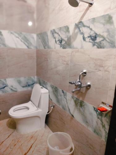 a bathroom with a toilet and a sink at Hotel Rinkesh Grand in Aurangābād
