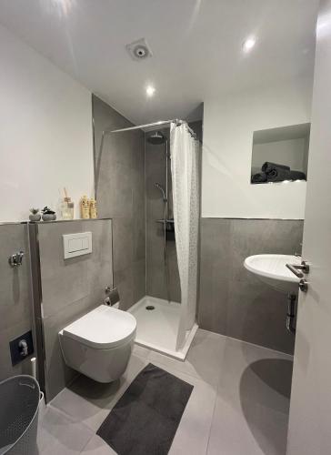 a bathroom with a toilet and a shower and a sink at Klytti‘s Pension in Sendenhorst