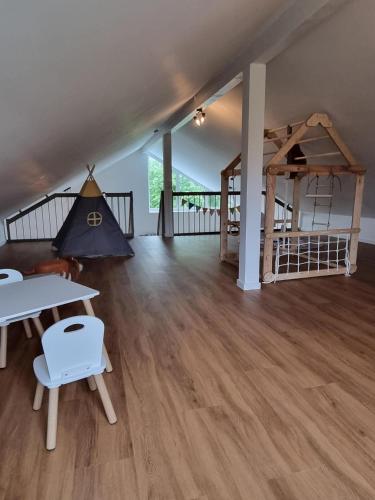 a living room with a table and a bed at freistehendes Ferienhaus mit Sauna und Badefass in Sehestedt