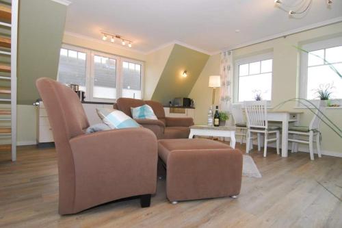 a living room with two chairs and a table at Wodan, Whg 2 in Tinnum