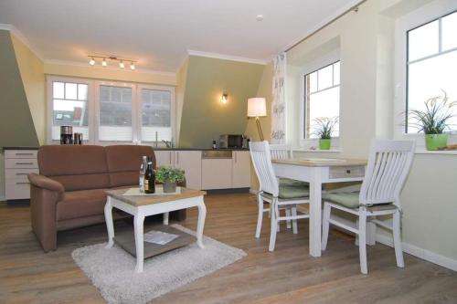 a living room with a couch and a table and chairs at Wodan, Whg 2 in Tinnum
