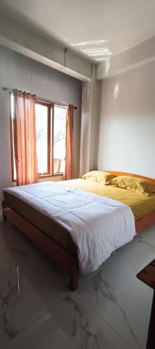 a large bed in a bedroom with a window at Toraja Hikari Homestay in Rantepao