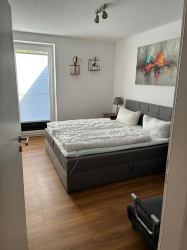 a bedroom with a large bed and a window at Gemütliches Ferienhaus mit Sauna an der Nordsee in Sehestedt