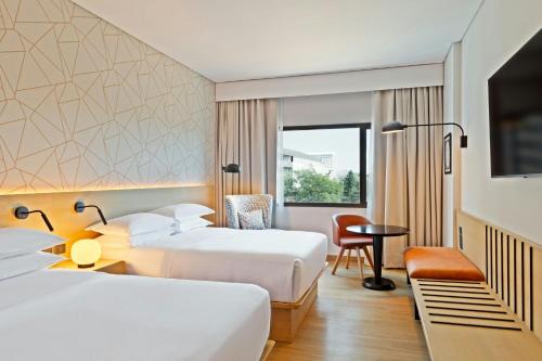 a hotel room with two beds and a desk at Sheraton Asuncion Hotel in Asunción