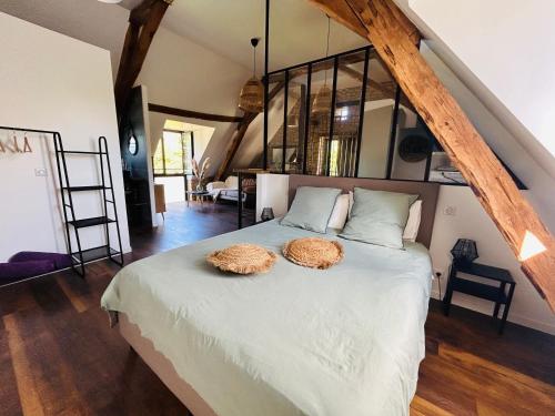 a bedroom with a bed with two hats on it at Les Noyers De Gaudelle in Saint-Sozy