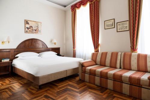 a hotel room with a bed and a couch at Hotel Boccaccio in Florence