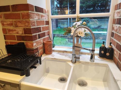 a kitchen sink with a faucet next to a brick wall at Bradford Canal Pump House, Shipley near Saltaire in Shipley