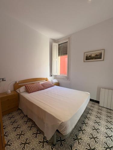 a bedroom with a bed and a window at Apartamentos Nouvilas in Portbou