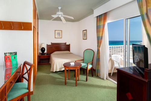 a bedroom with a bed and a balcony with the ocean at Hotel Riu Oliva Beach Resort - All Inclusive in Corralejo