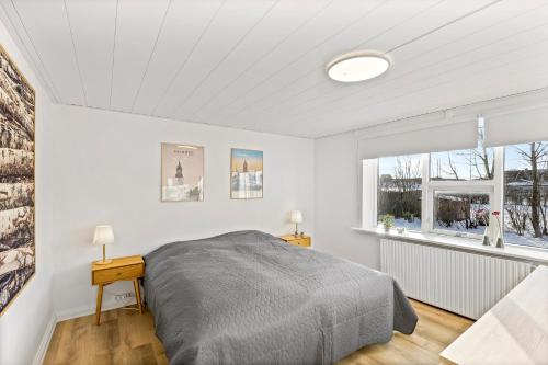 a white bedroom with a bed and a window at FeWo Vidstrup Have in Vidstrup