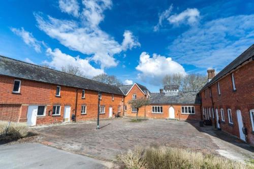 a row of brick buildings with a parking lot at Redwood Escape Stylish New Forest Stay Sleeps 4 Near Paultons Park in Ower