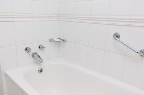 a bathroom with a white sink and two faucets at 5-Min Walk to CTICC - Central & Cosy Hotel Stay in Cape Town